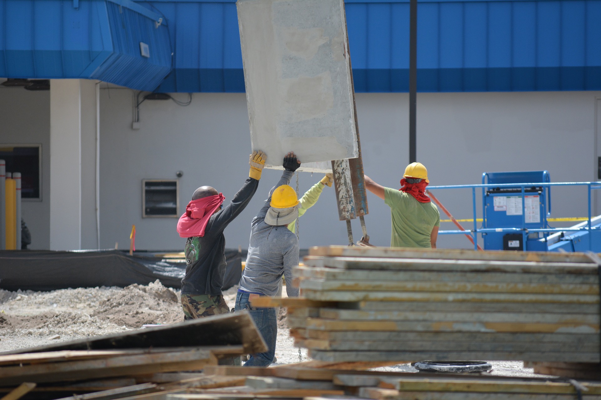 Chantier avec ouvrier soulevant des dalles de béton